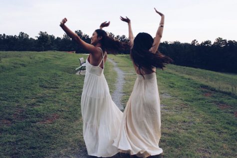 Pre-homecoming antics dictate that these girls spin around in their flowing dresses and loose hair.