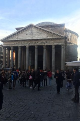 Masses of people crowd around the Pantheon as it stands in all its glory. 
