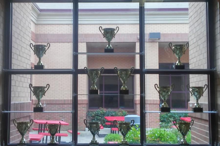 Trophy case featured from the main hallway of Lambert High School, with a courtyard backdrop