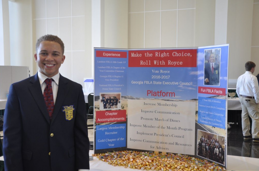 Student Royce Dickerson stands proud beside his poster displaying his campaign, smartly titled Roll With Royce.