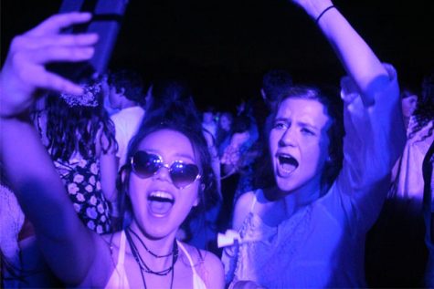 Under the black lights on the practice field, students dance to the classic hit: "Apple Bottom Jeans" by Flo Rida.