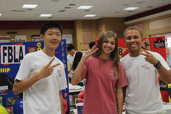 Georgia FBLA President Royce Dickerson and fellow FBLA members, Henry Xuan and Jessie Bowman, smile at the camera right before the freshmen flooded the cafeteria.