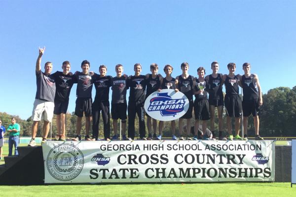 The Lambert boys cross country celebrates their state title win on top of the podium