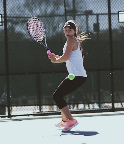 Brenna Reilly swings a backhand as the ball comes toward her.