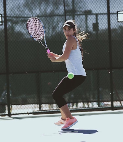 Brenna Reilly swings a backhand as the  ball comes toward her.