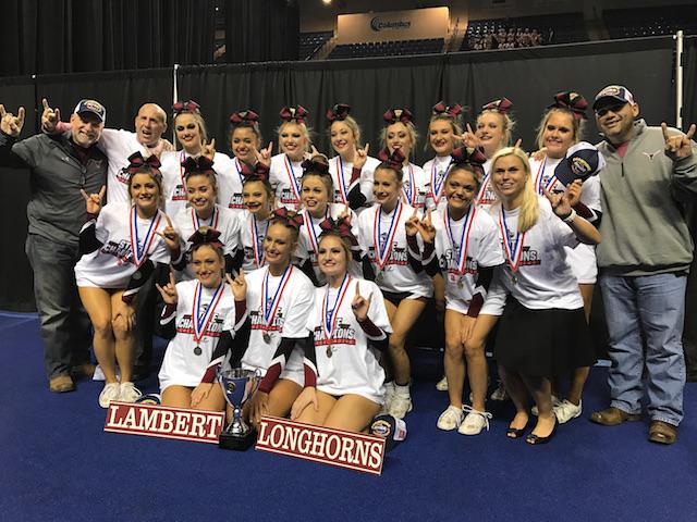 The+competition+cheerleaders+pose+for+a+picture+with+their+state+trophy.