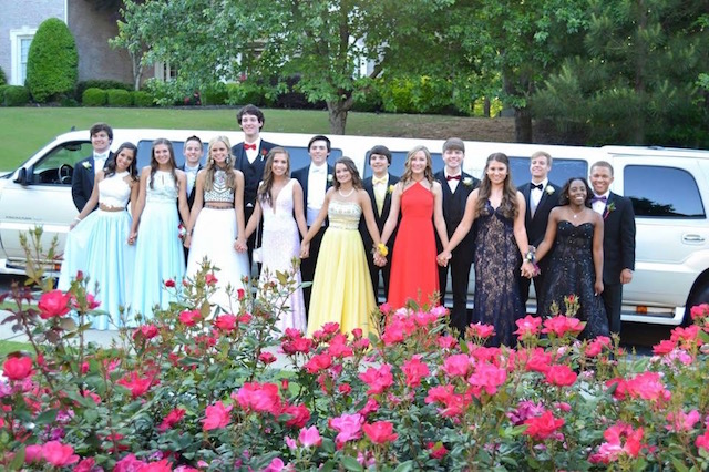 A prom group stands in front of their limo before leaving for the dance.