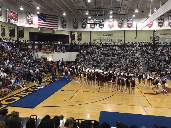 Cheerleaders create a tunnel for this season's football team to pass through. 