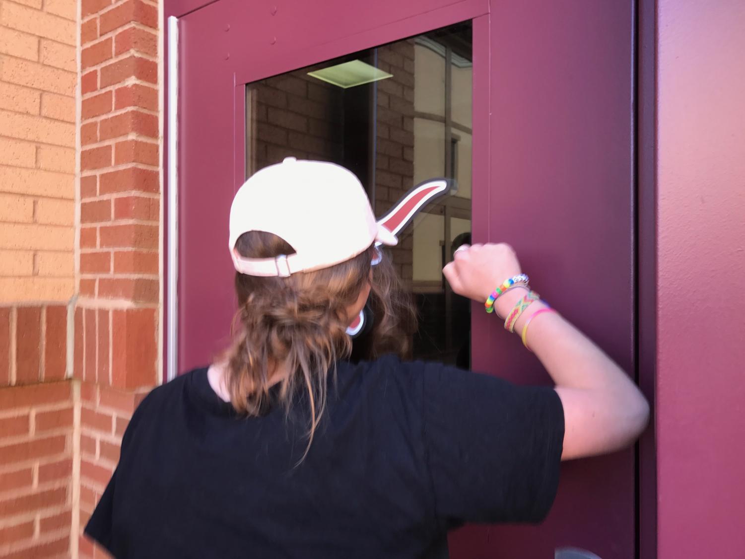 A Lambert student encounters a locked door while trying to enter the school building and must wait for someone inside to hear her knocking.
