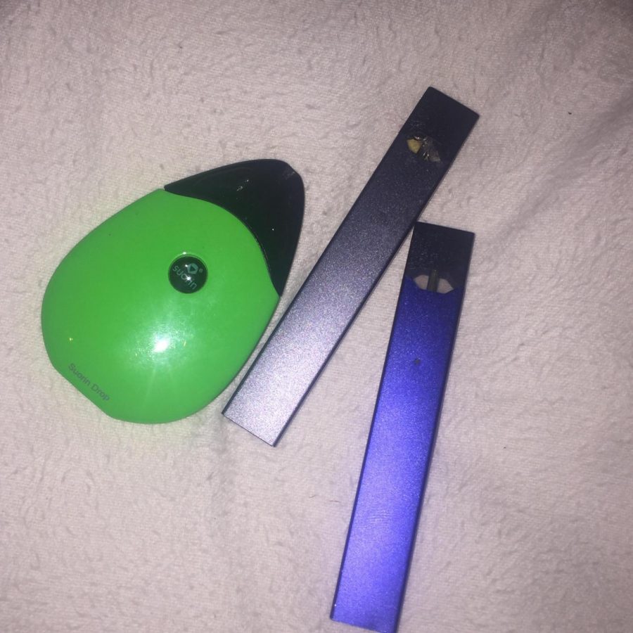 This picture features a Sourin drop and two Juuls. These e-cigs are just a few on the market that give teens the opportunity to get buzzed.