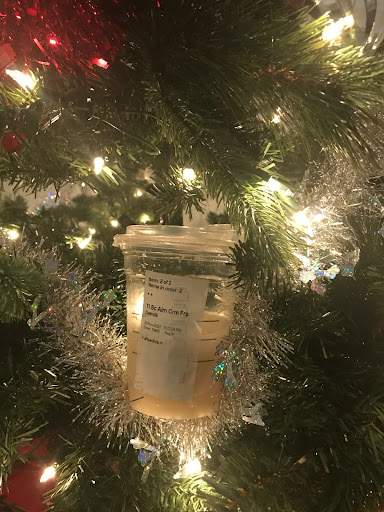 Photo of a half drank Sugar Cookie Oat Milk Latte in front of holiday decorations. Tuesday, November 30th, 2021. This seasonal frappuccino from Starbucks was flavorful and lit up the cold November night. (Samantha Nyazema)
