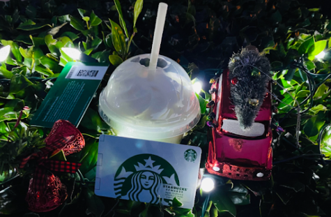 Photo of a seasonal Starbucks drink surrounded by festive decorations and Starbucks gift cards. Taken on Tuesday, December 13th, 2022. 