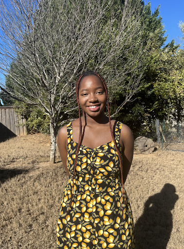 Martha smiling outdoors in a lemon dress. (Provided by Martha Mwangi)
