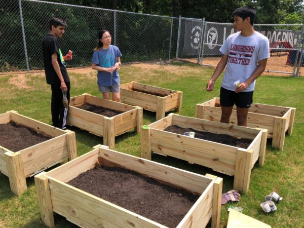 Change Earth club members pose in front of their newly built garden after a buddy day of planting. (Armaan Bhasin/The Lambert Post)