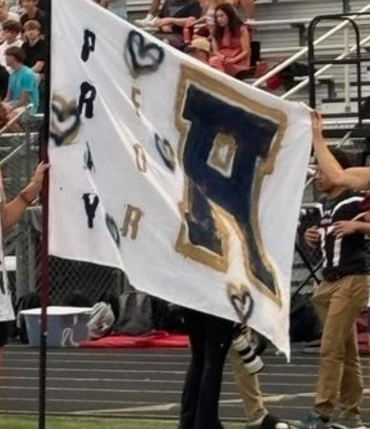 Lambert students hold a ‘Pray for Apalachee’ flag during a football game. (Lambert DRN)
