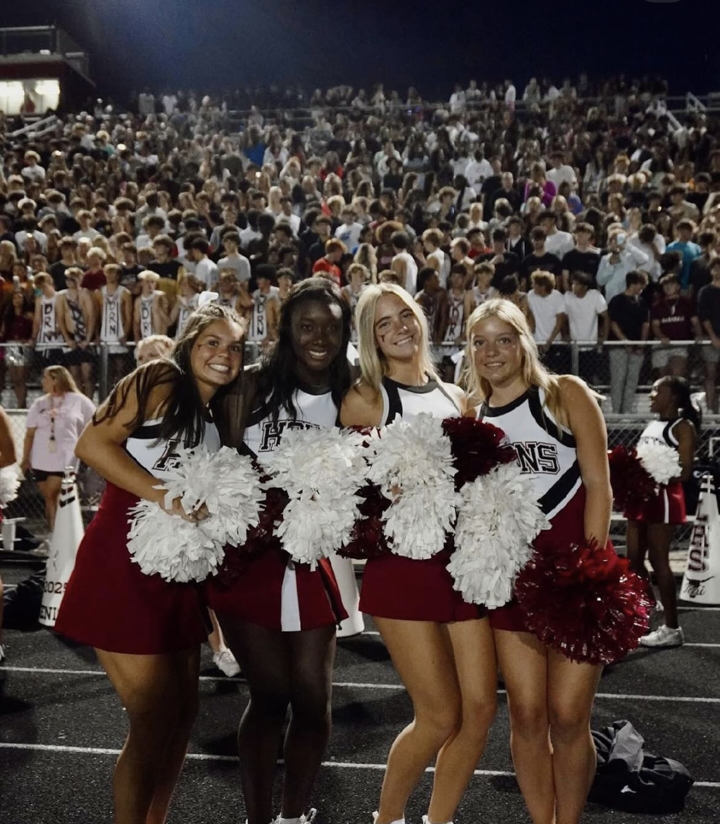 (Jessie Ledbetter and her teammates on the sidelines cheering on the football team at Lambert Highscchool)

