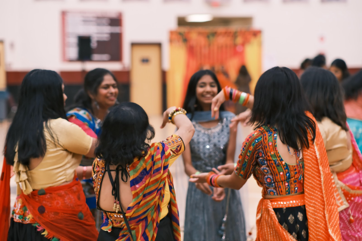 The image shows a group of people doing a Garba dance during the Garba X Diwali event. (Riya Shah)