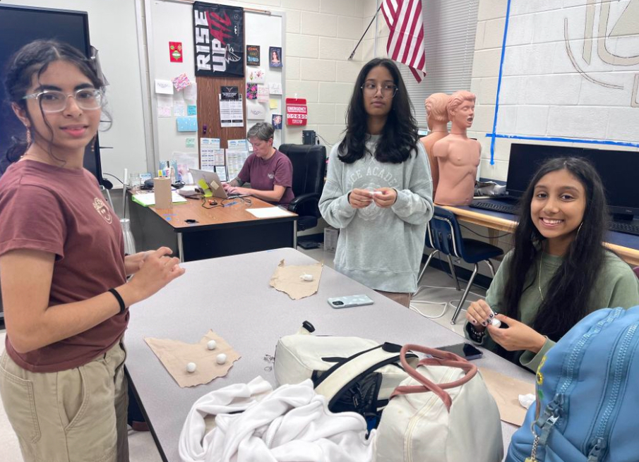 The image shows (left to right) freshmen Rachita Kawale, Arpita Bepeta and Eeshal Gupta working on their clay replica of a human bone. (Chloe Jang/HOSA)