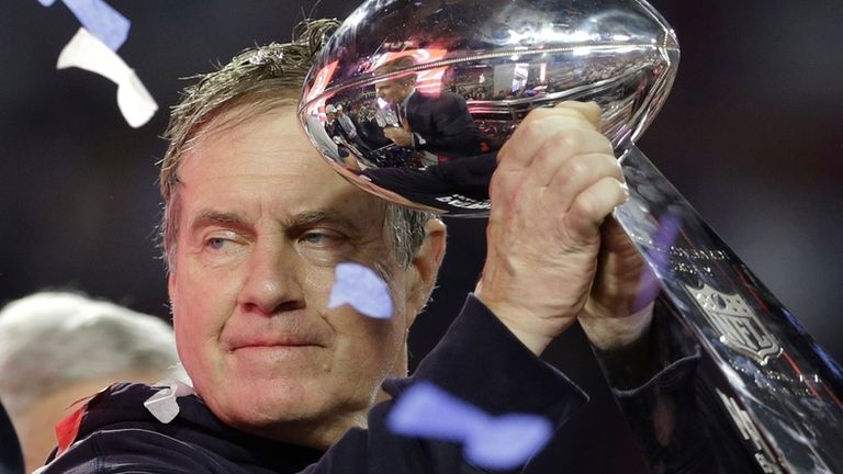 Bill Belichick holding up a Super Bowl trophy after beating the Seahawks (royaltyfreepics).


